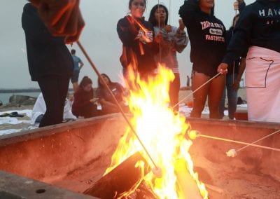 San Diego Christian College students roast marshmallows in a campfire on the beach