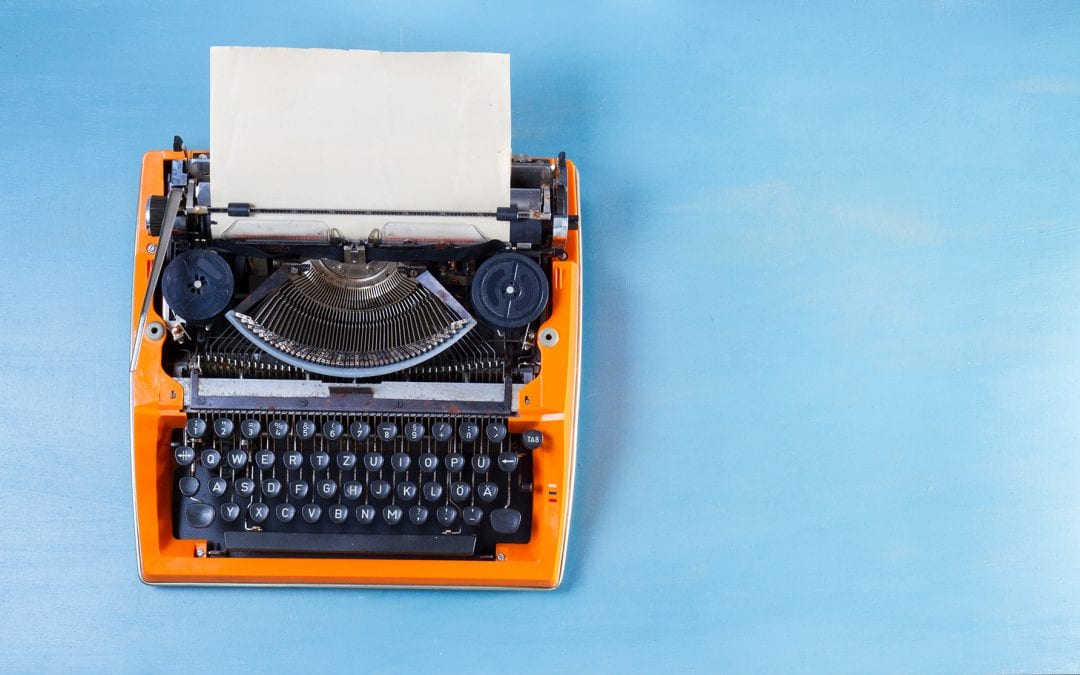 bright oran typewriter on a blue background