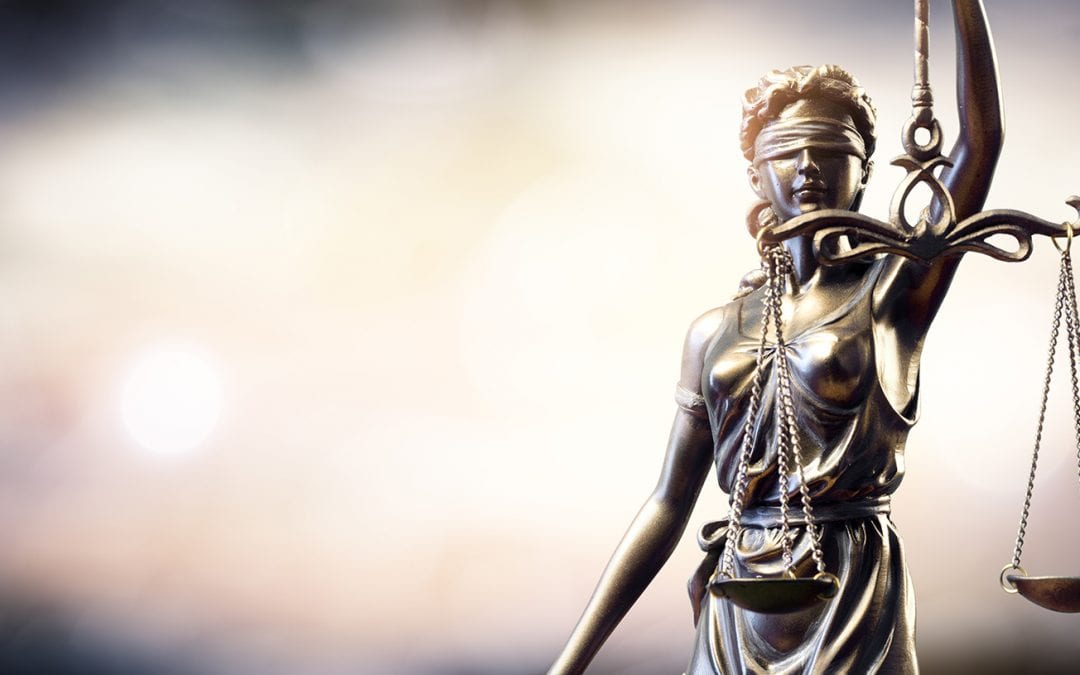 lady justice wields her sword and uses her scales to determine right from wrong